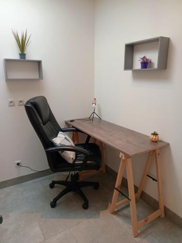 un bureau avec un bureau en bois et une chaise noire dans l'établissement Studio refait à neuf, à Amiens