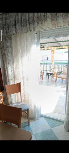 a room with a view of a patio with a table and chairs at Ático con terraza en el centro de Punta Umbría in Punta Umbría