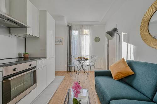 un salon avec un canapé bleu et une table dans l'établissement Le Poétique niché au pied du Sacré-Cœur, à Paris