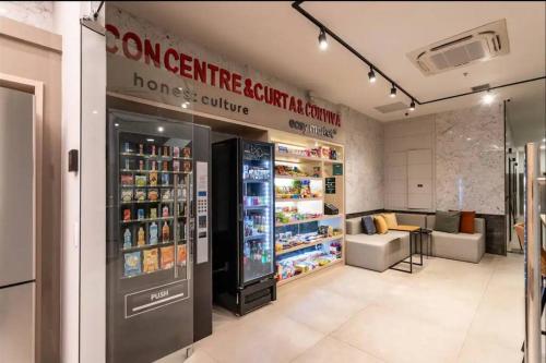 a store with a drink refrigerator in a room at Apartamento completo e moderno com ar condicionado e piscina no centro do RIO in Rio de Janeiro