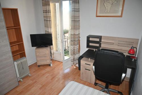 un bureau avec un bureau, une chaise et une télévision dans l'établissement Chambre meublée Cannes, à Cannes