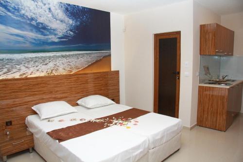 a bedroom with a bed and a painting of the beach at Diamond Kiten in Kiten