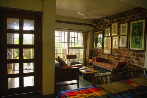 un salon avec un canapé et un mur de briques dans l'établissement Srirangam, Shantiniketan, à Srī Niketan