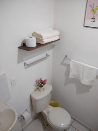 a white bathroom with a toilet and a sink at Casa Okadiz in Rancho de la Cruz