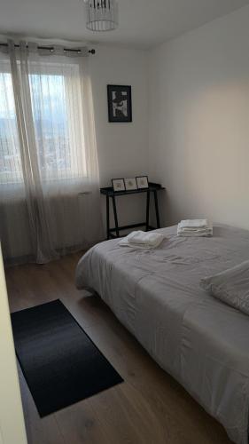 une chambre blanche avec un lit et une fenêtre dans l'établissement Le sept, à Colmar