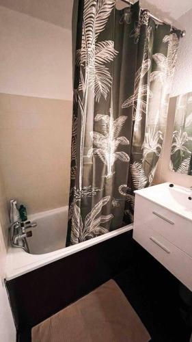 La salle de bains est pourvue d'un rideau de douche noir et blanc. dans l'établissement Chez Simon, à Risoul