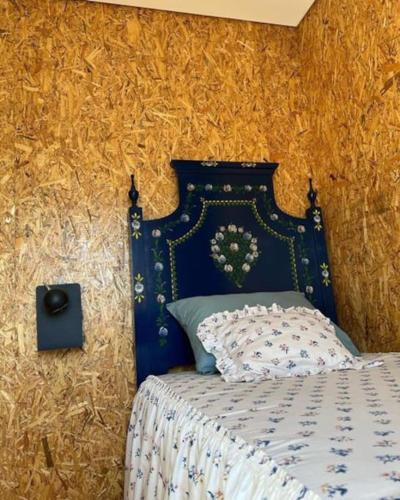 a bedroom with a bed with a blue head board at Refúgio da Águia in Montargil
