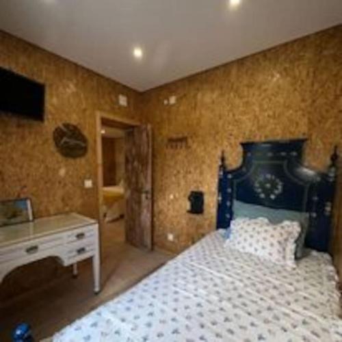 a bedroom with a bed and a dresser and a desk at Refúgio da Águia in Montargil