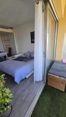 - une chambre avec 2 lits et une porte coulissante en verre dans l'établissement Studio agreable avec parking privé, à Cagnes-sur-Mer