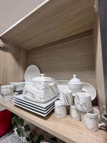 a shelf with white dishes and cups on it at New Downtown studios in cairo in Cairo