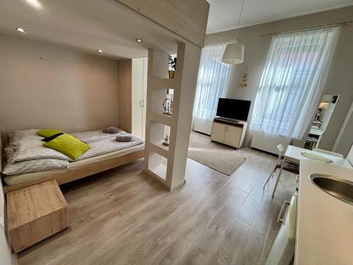 a bedroom with a bed with yellow pillows and a television at Ava Central Residence in Budapest