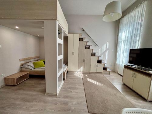 a room with a staircase with a bed and a television at Ava Central Residence in Budapest