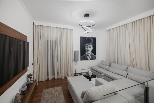 a living room with a white couch and a tv at The Palm Terrace Penthouse 3BR - Palm Hills - 280 sqm in Cairo
