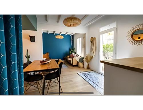 a dining room and living room with a blue wall at Séjour mexicain cosy & romantique - CommeChezSoi in Avignon
