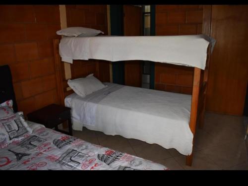 two bunk beds in a room next to a bed at Hotel Ciudad Dulce Moniquira in Moniquirá