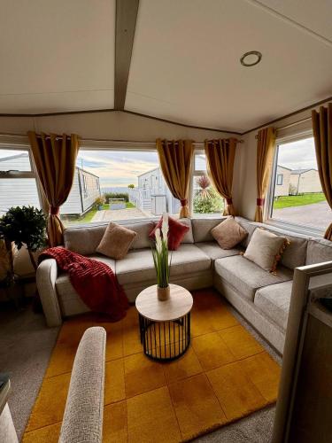 a living room with a couch and a table at Holiday home in Durdle door with stunning Sea view in West Lulworth