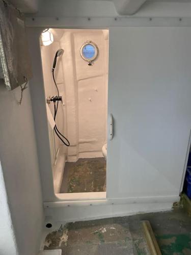 Cette chambre comprend une petite salle de bains pourvue d'une douche. dans l'établissement Louez Notre Bateau Immobilisé !, à Grosbreuil