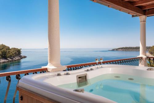 a jacuzzi tub on a balcony overlooking the ocean at Villa Amfora Korcula - Six bedroom villa with amazing view in Blato
