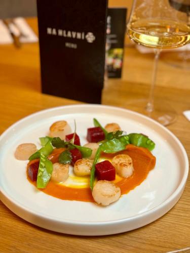 a plate of food on a table with a glass of wine at Hotel Frýdl in Prague