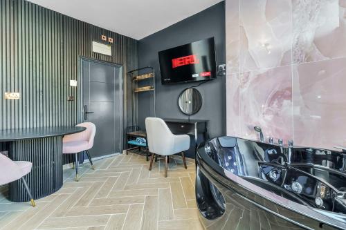 a bathroom with a tub and a tv on the wall at G Eighty Four in London