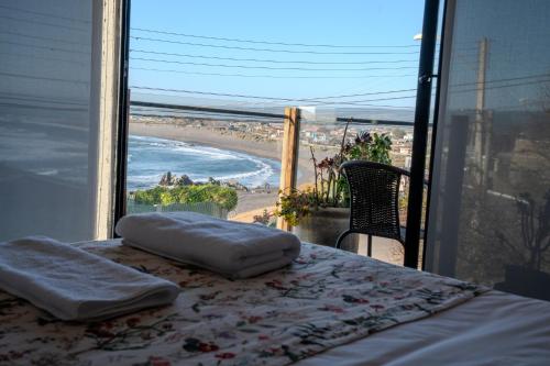 a bedroom with a bed and a view of a beach at Hotel Boutique Aldea del Mar in Pichilemu