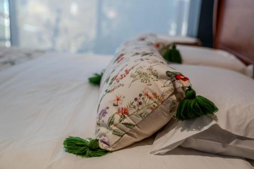 a pillow on a bed with flowers on it at Hotel Boutique Aldea del Mar in Pichilemu