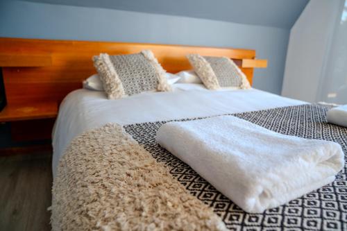a bedroom with two beds with white sheets and pillows at Hotel Boutique Aldea del Mar in Pichilemu