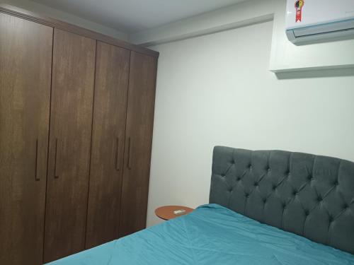 ein Schlafzimmer mit einem Bett und Holzschränken in der Unterkunft Apartamento Frente Mar in Barra Velha