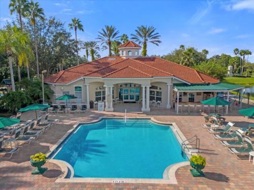 a pool at a resort with chairs and umbrellas at Spring retreat near Disney, Perfect for families in Kissimmee