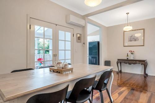 a dining room with a large wooden table and chairs at Charming Blue Mountains Cottage Katoomba in Katoomba