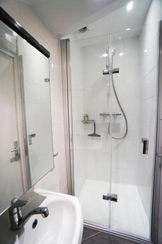 une salle de bain blanche avec une douche et un lavabo dans l'établissement Appartement 2 pièces 