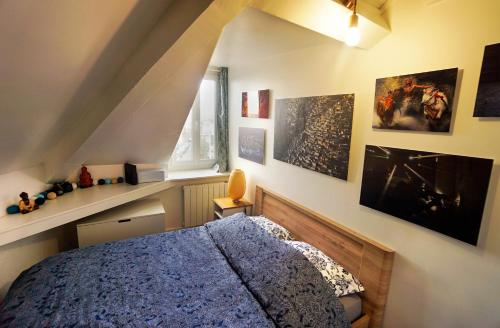una camera con letto blu e alcune immagini sul muro di Appartement 2 pièces "Le Cocon Urbain" - Rénové et Cosy - Proche Paris & Disneyland a Neuilly-Plaisance