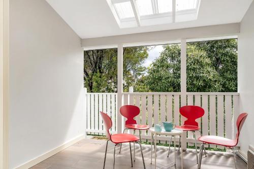 a room with red chairs and a table and a window at Charming Blue Mountains Cottage Katoomba in Katoomba