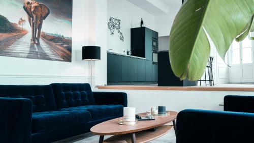 un salon avec des canapés bleus et une table dans l'établissement Le Jeanne d'Arc, à Chinon