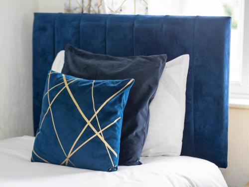 a blue pillow sitting on top of a bed at Spacious 3BR Home with Driveway Near NEC & Airport in Birmingham