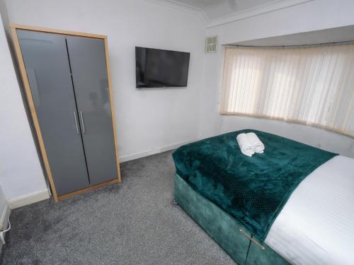 a bedroom with a bed and a flat screen tv at Spacious 3BR Home with Driveway Near NEC & Airport in Birmingham