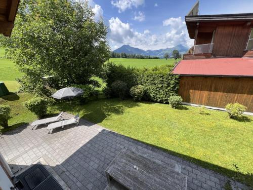 a garden with a bench and an umbrella at Maxima - Ski in - Ski Out in Flecken