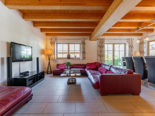a living room with a red couch and a flat screen tv at Maxima - Ski in - Ski Out in Flecken