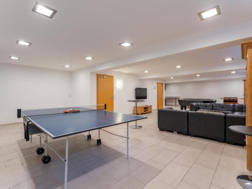 a room with a ping pong table and a couch at Maxima - Ski in - Ski Out in Flecken