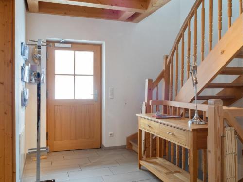 a hallway with a wooden staircase and a door at Maxima - Ski in - Ski Out in Flecken