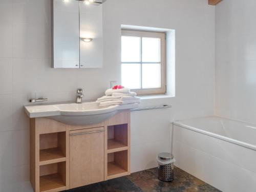 a white bathroom with a sink and a window at Maxima - Ski in - Ski Out in Flecken