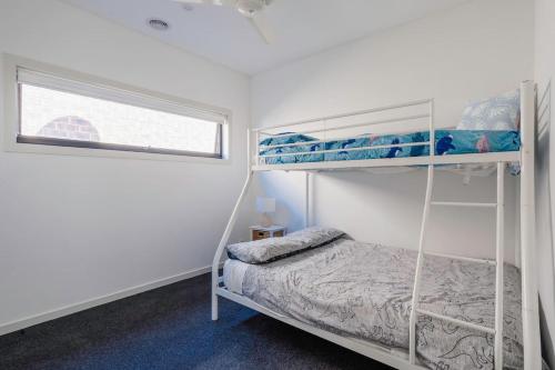 a bedroom with two bunk beds and a window at 'The Leon' A Family Friendly Coastal Abode in Rosebud