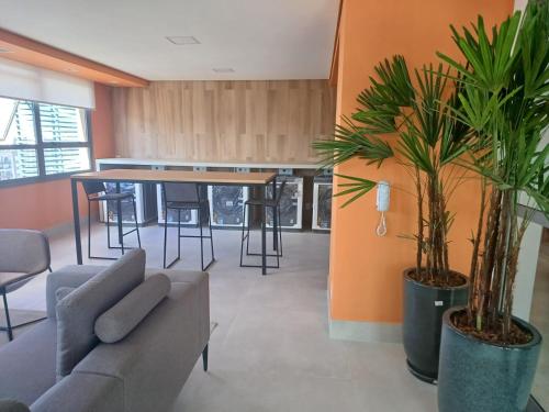 a living room with a couch and a table with plants at Metrô Studio Alto do Ipiranga in Sao Paulo