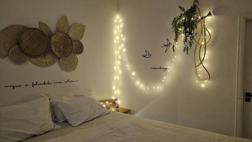 1 dormitorio con 1 cama con luces en la pared en Cabana na montanha com Ofurô ao ar livre, churrasqueira, trilha com cascata e Starlink, en Cambuí