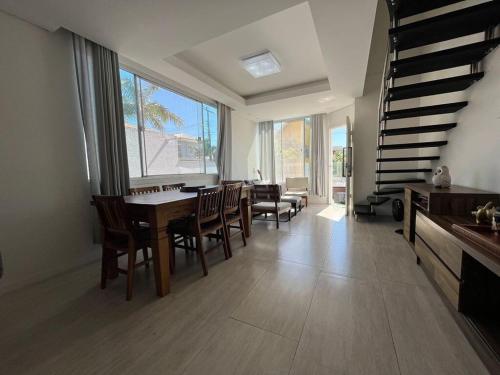 une salle à manger avec une table et des chaises et des escaliers dans l'établissement Casa Palmas, à Governador Celso Ramos