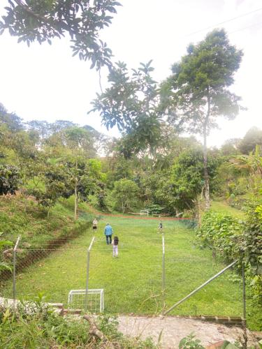 a group of people standing in a grass field at Finca la vaga in Filandia