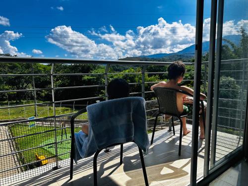 two people sitting on a balcony looking out at the mountains at El rincón de Tonella Apartamento completo muy equipado in Ibagué