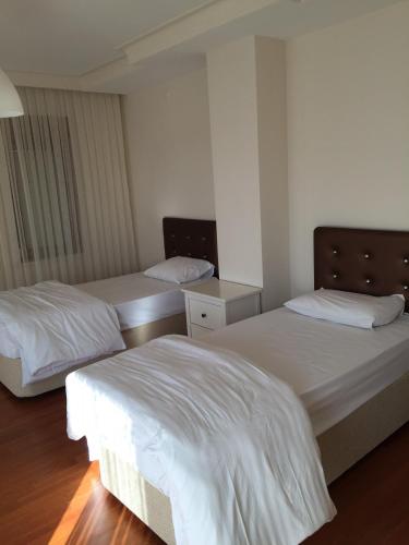 two beds in a room with white sheets at Villa Bursa in Bursa