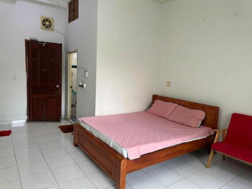 ein Schlafzimmer mit einem Bett und einem roten Stuhl in der Unterkunft CoCo home 15 in Ho-Chi-Minh-Stadt