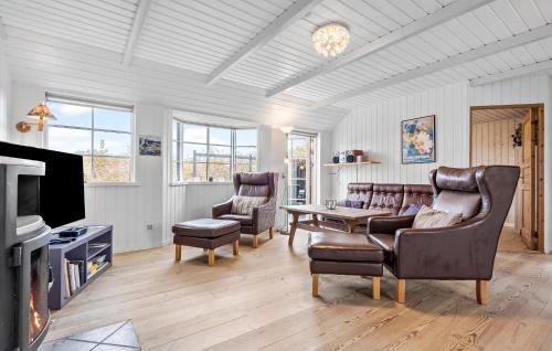 a living room with leather chairs and a tv at Holiday Home Ildervej Hemmet Denmark in Hemmet